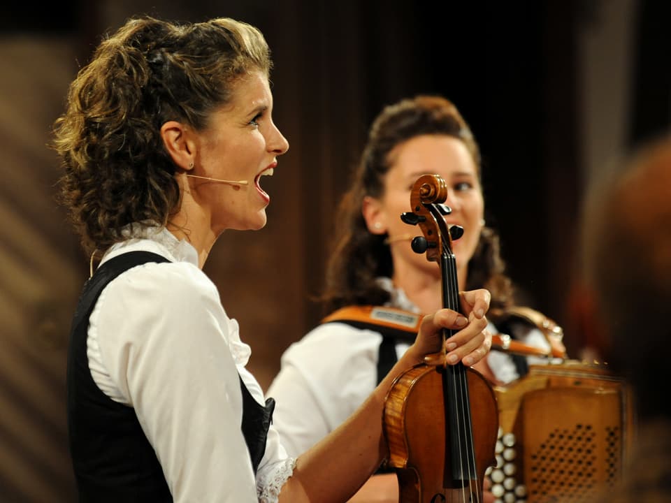 Claudia Heis von den "Die Hoameligen" hält Geige in Hand und singt.