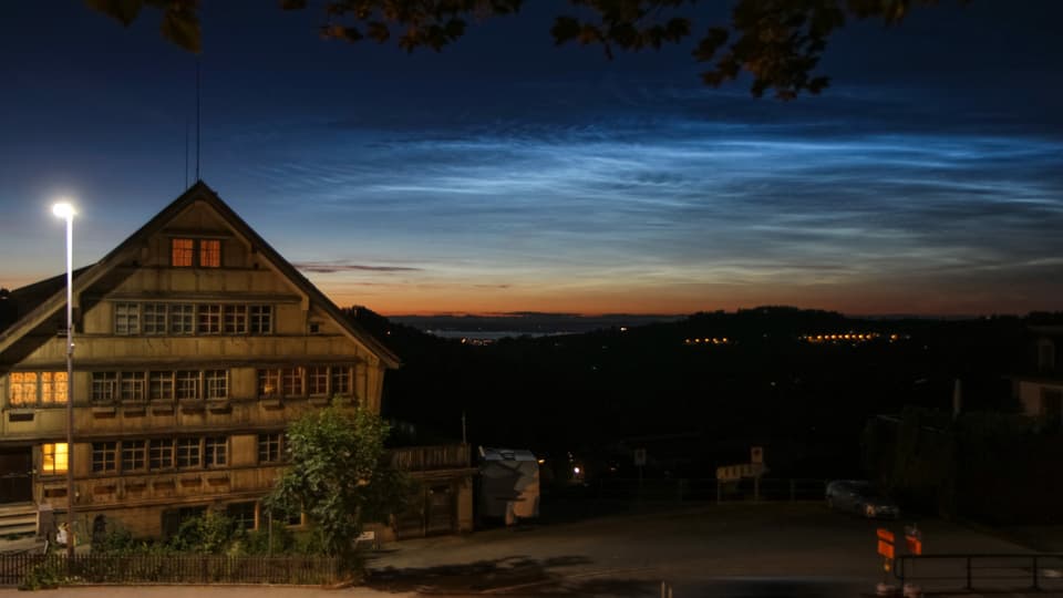 Leuchtende Nachtwolken Am Horizont ist rötlich das Abendrot zu sehen, darüber die bläulichen Leuchtenden Nachtwolken.