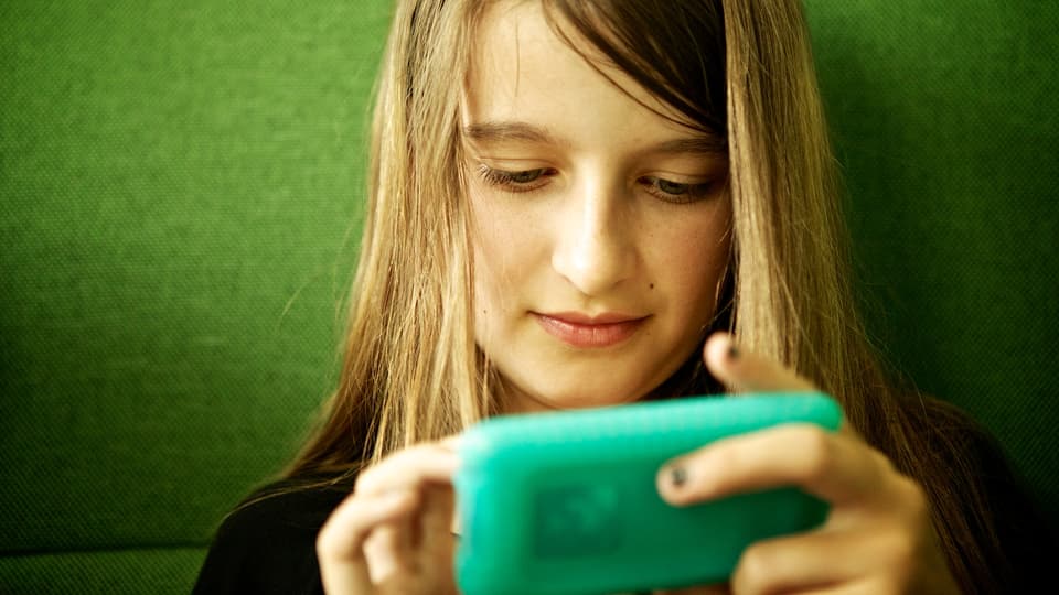 Ein Mädchen schaut in einen iPod Touch.
