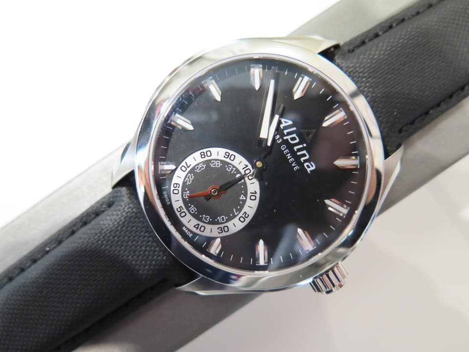 Eine Uhr von Alpina mit schwarzem Ziffernblatt.