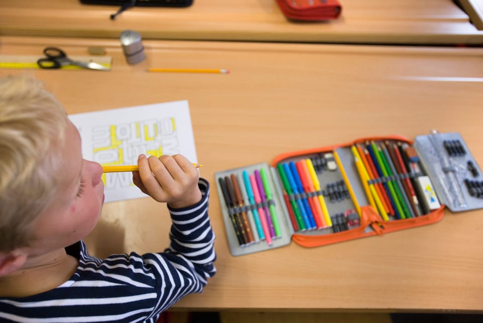 Kind mit Etui und Stiften