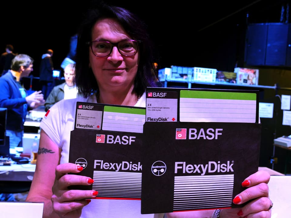 Frau hält zwei grosse FlexyDisk-Disketten.