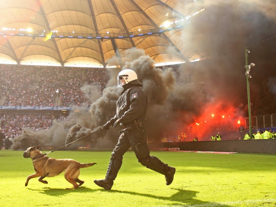 Sicherheitskräfte stürmen den Platz, nachdem HSV-Fans aus dem «Schwarzen Block» in der Nachspielzeit Rauchpetarden gezündet hatten.