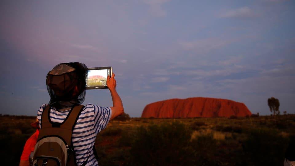 Junge fotografiert den Uluru