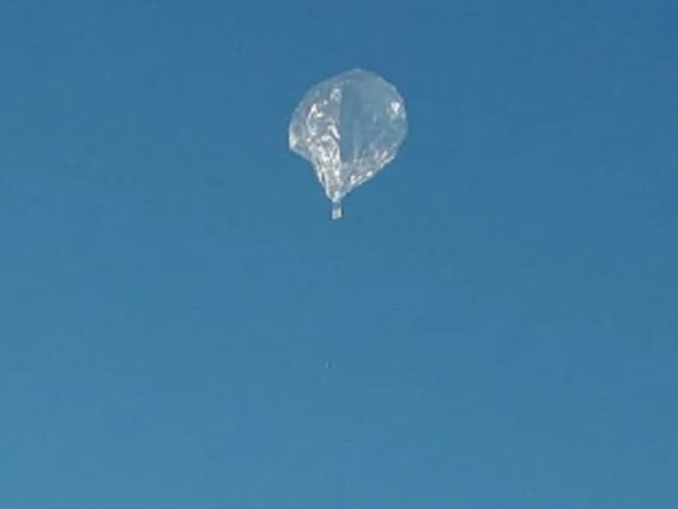 Ein Amateur-Höhenballon steigt in die Luft. Im Hintergrund blauer Himmel.