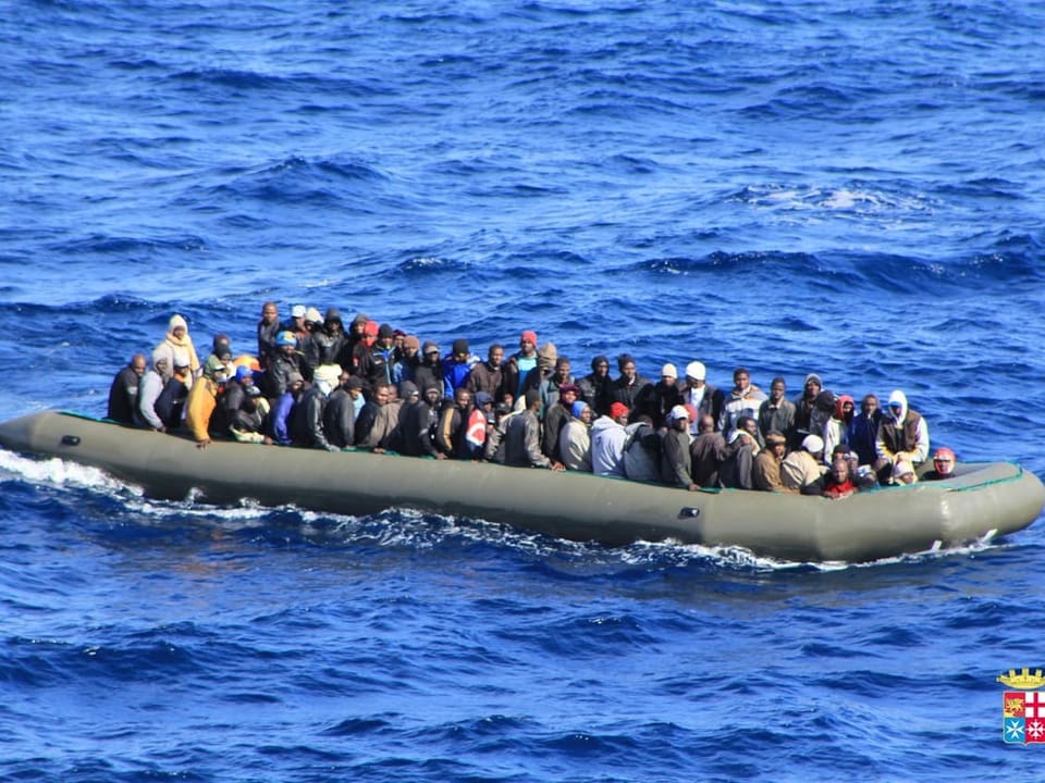 Gummiboot im Meer mit Dutzenden Personen drauf