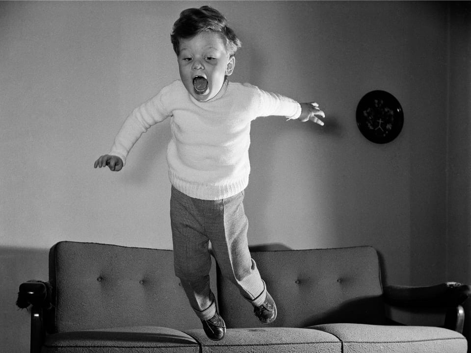 Ein Kind springt von einem Sofa