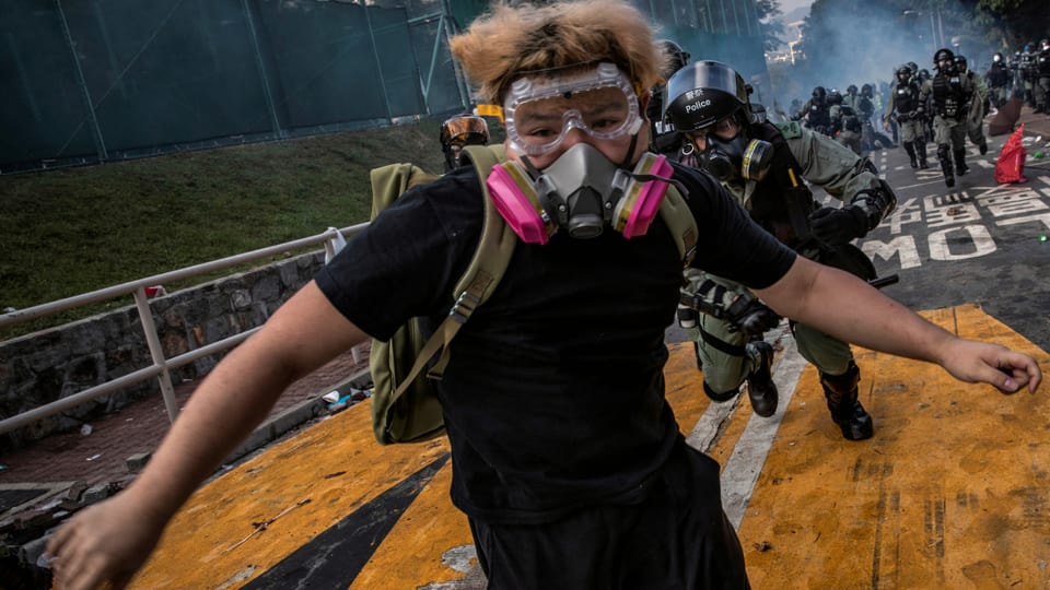 Ein Demonstrant rennt vor einem Polizisten weg