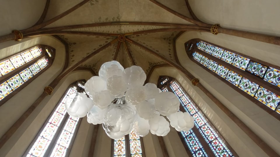 Eine Wolke aus Glaselementen hängt in einem Kirchen-Chor