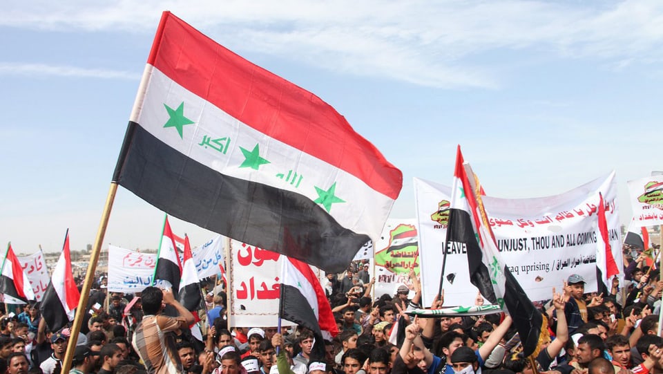 Sunnitische Demonstranten mit Fahnen und Bannern.