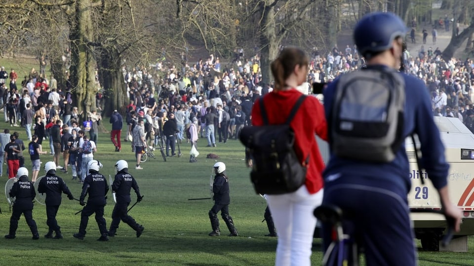Massentreffen in einem Park, Polizei schreitet ein. 