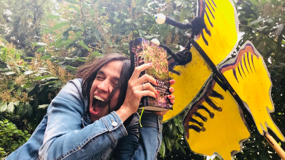 Annette König hält das Buch «Die Tyrannei des Schmetterlings» als Schutzschild gegen ein Insekt