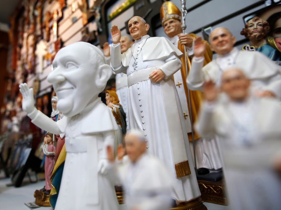 Kleine weisse Statuen von Papst Franziskus.