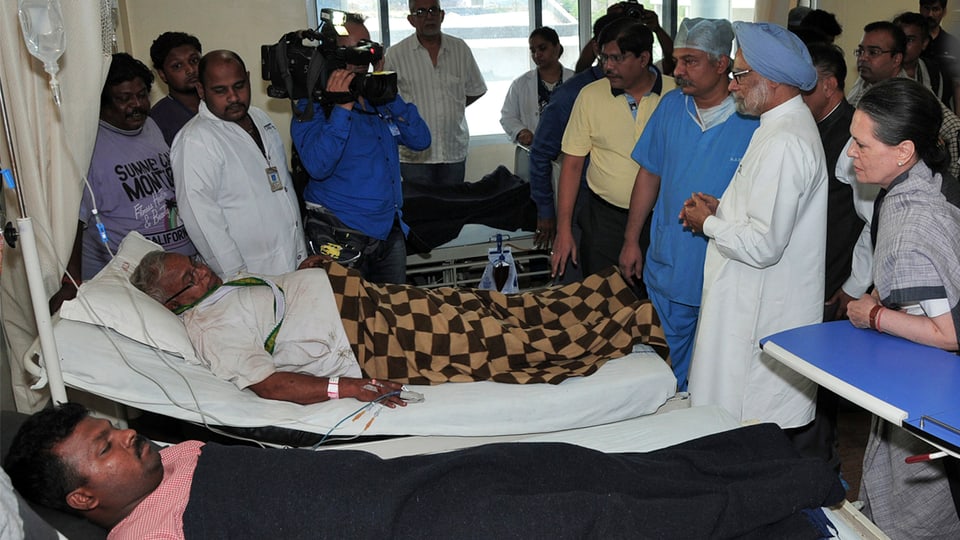 Premierminister Manmohan Singh an einem Krankenbett.