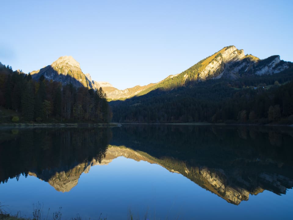 Der See wie ein Spiegel, Berge Spiegeln sich darin.