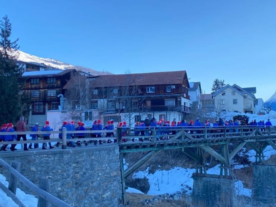 Eine Gruppe blau gekleideter Kinder läuft über eine Brücke.
