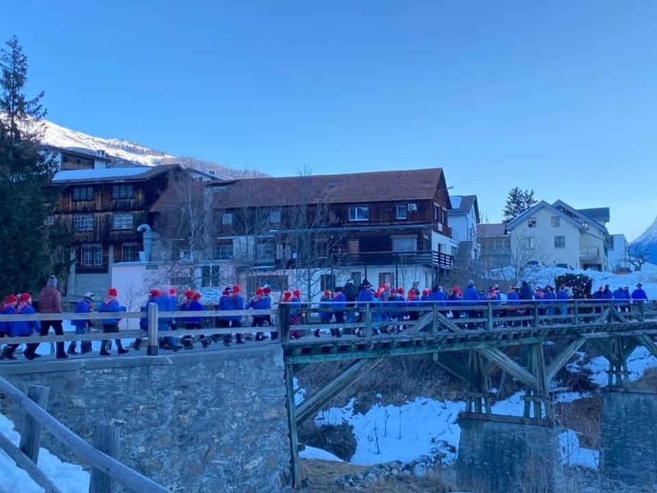 Schulklassen Eine Gruppe blau gekleideter Kinder läuft über eine Brücke.