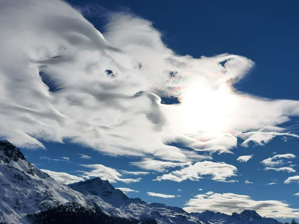 Blauer Himmel in den Alpen mit vielen wellenförmigen Wolken.