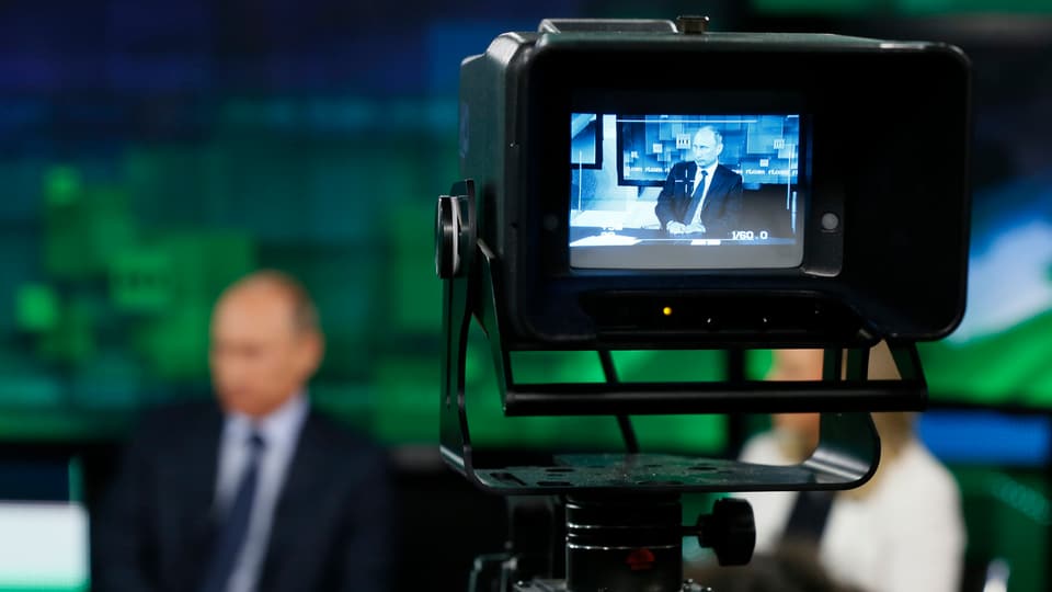Eine Fernsehkamera zeichnet im Vordergrund den russischen Präsidenten Wladimir Putin auf.