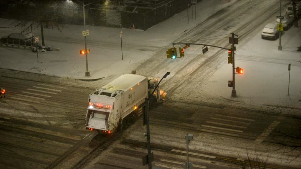 Ein Schneepflug räumt die Strasse frei. 