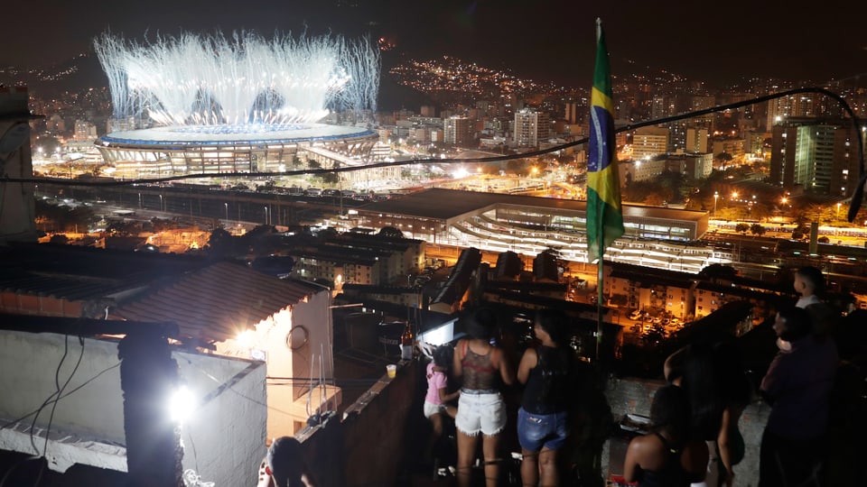 Bewohner der Mangueira-Favela schauen die Eröffnungsfeier aus der Ferne.