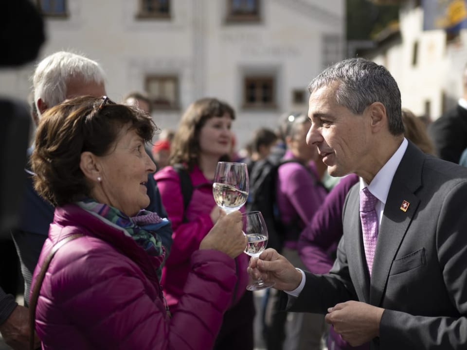 Ignazio Cassis stösst mit einer Besucherin in Müstair an