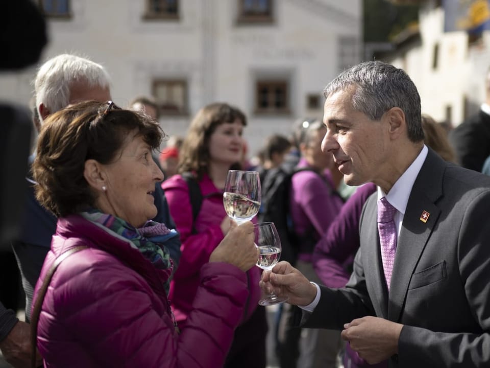 Ignazio Cassis stösst mit einer Besucherin in Müstair an