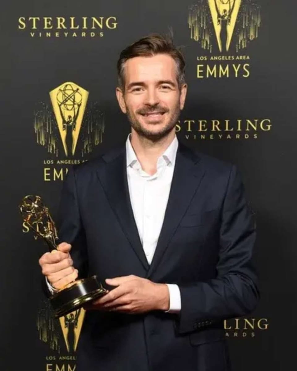 Mark Bächle gewinnt einen Emmy Mann mit Trophäe in der Hand