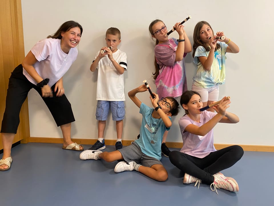 fünf Kinder spielen Flöte vor einer weissen Wand