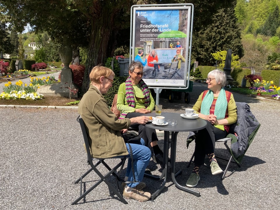 Drei Frauen trinken einen Café auf dem Friedhof.