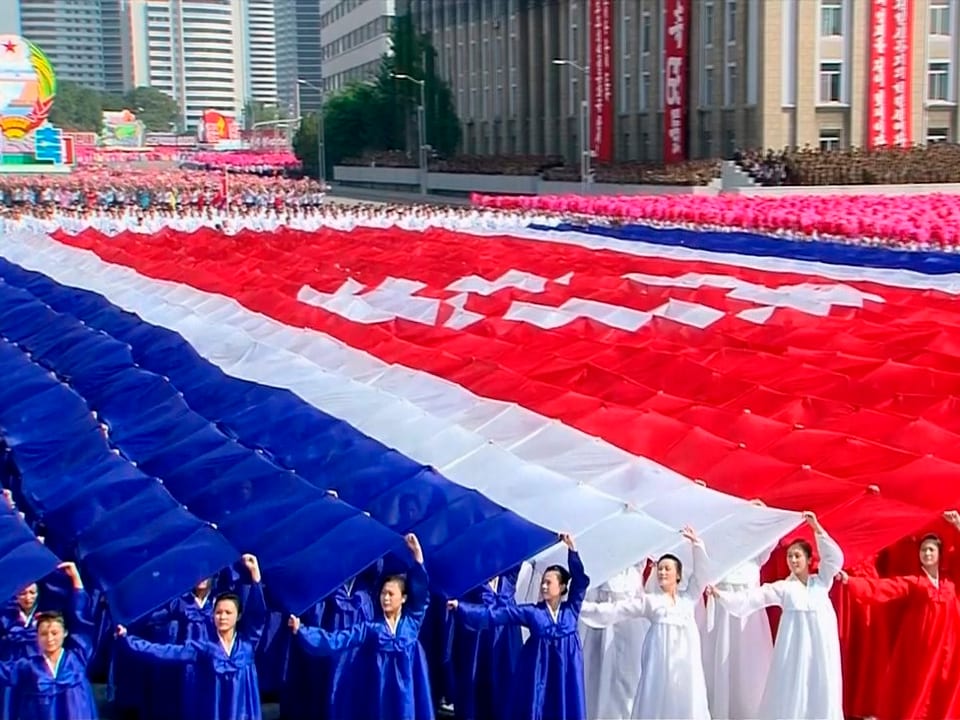 Nordkoreaner zeigen die nordkoreanische Flagge.