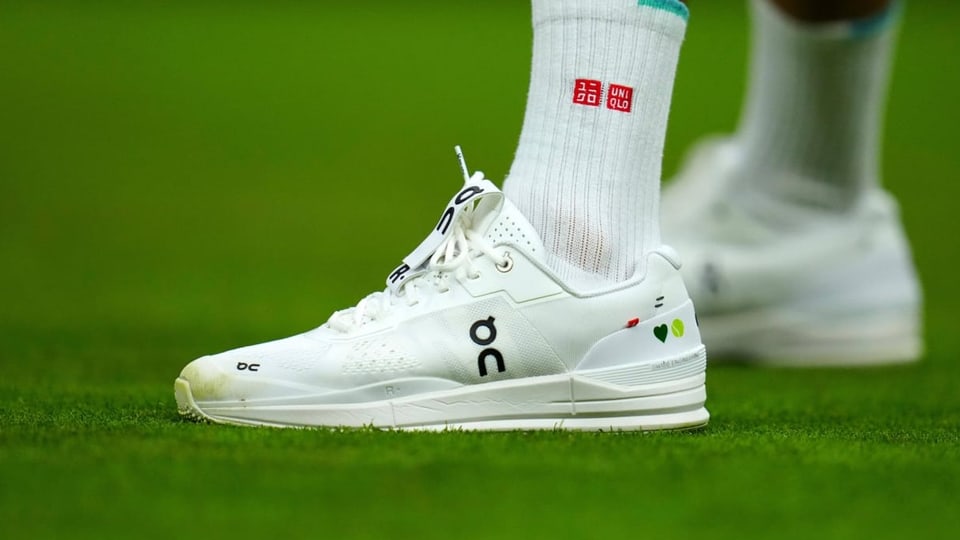 Die Schuhe der Marke On an Roger Federers Füssen während eines Erstrundenmatches in Wimbledon 2021.