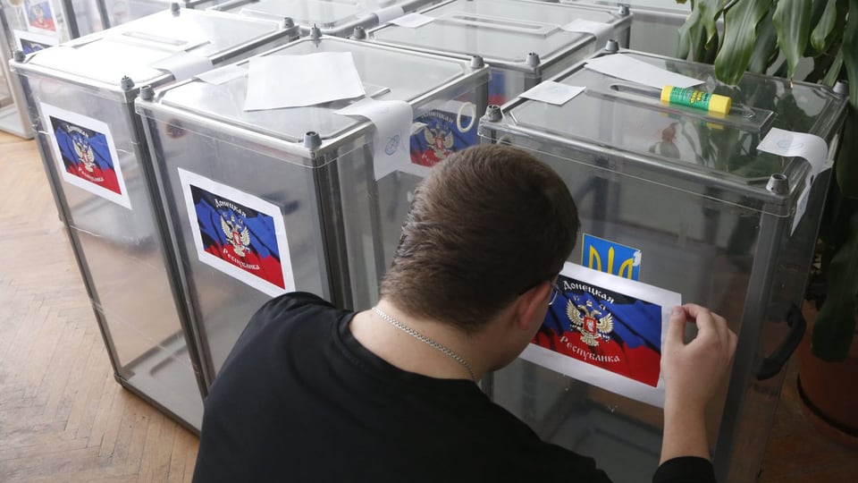 Ein Mann fertigt Wahlurnen an.