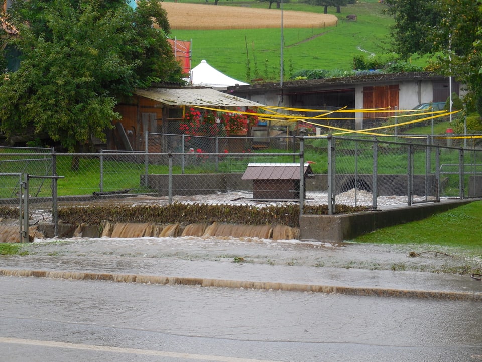Zäziwil BE Das Auffangbecken des Dorfbachs in Zäziwil ist voll. Das Wasser fliesst ungehindert über die Strasse.