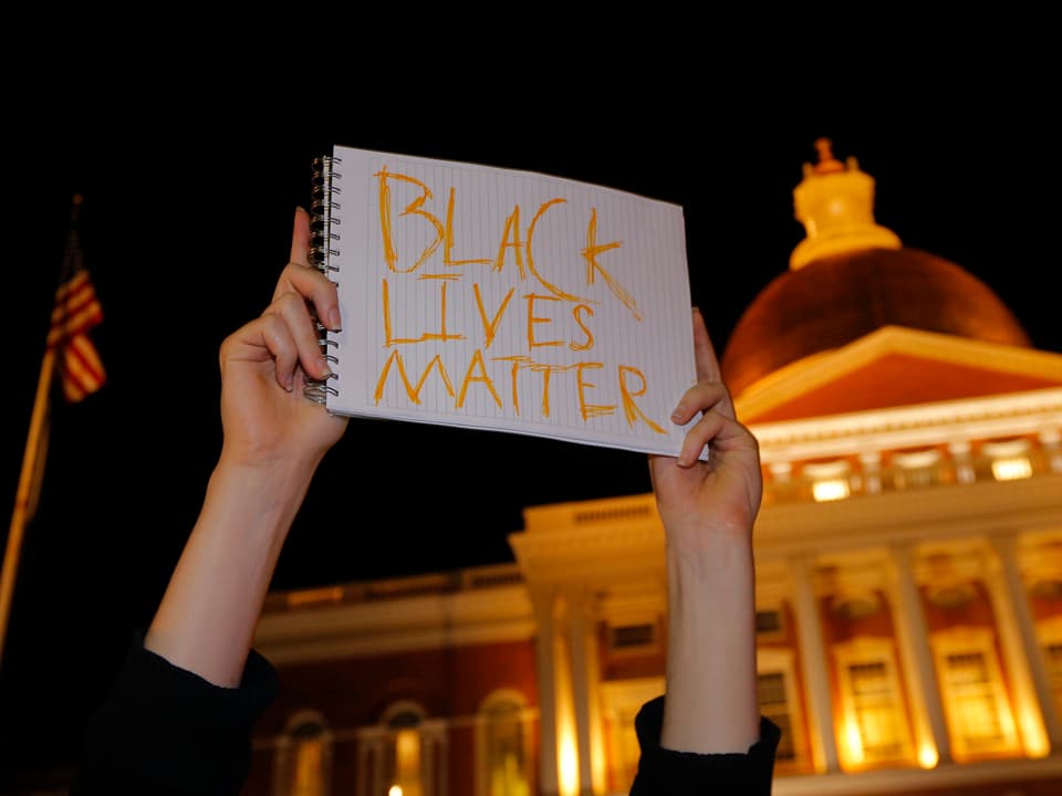 Demontrant hält Plakat mit Aufschrift «Black Lives Matter in die Luft»