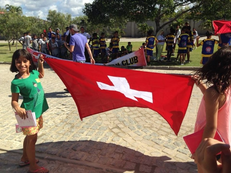 Zwei Mädchen halten eine Schweizer Fahne.
