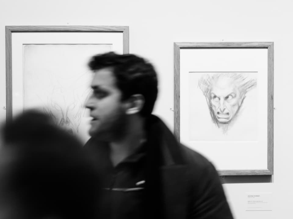 Ein Besucher im Musée Rath vor dem Bild eines Monsters.