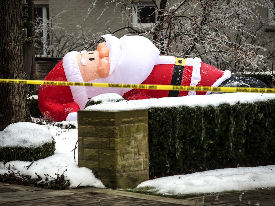 Übergrosser Weihnachtsmann liegt umgeblasen in einem Vorgarten Torontos.