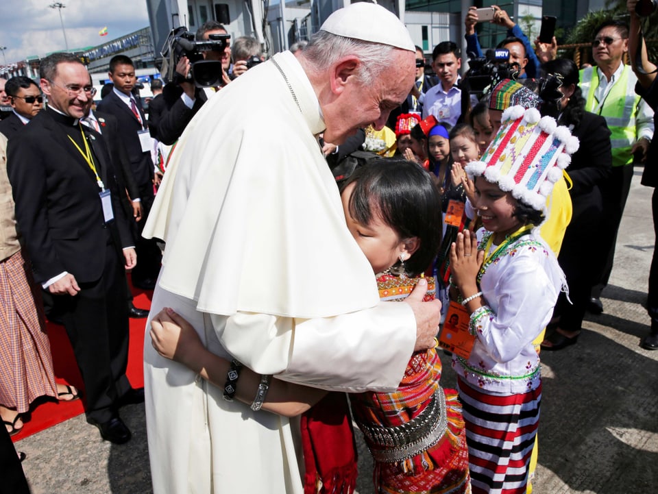 Ein Kind umarmt den Papst.