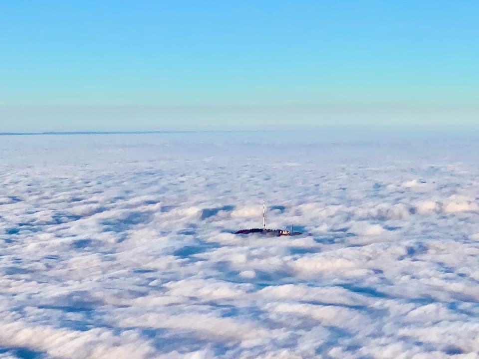 Nebelmeer mit Antenne auf kleinem Hügel