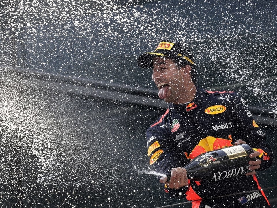 Der australische Formel 1 Pilot Daniel Ricciardo feiert seinen Sieg am GP von China mit einer Flasche Champagner.