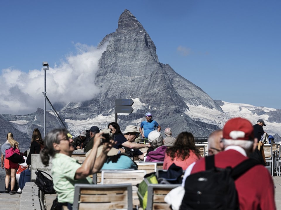 Das Matterhorn mit einer Touristenschar im Vordergrund. 