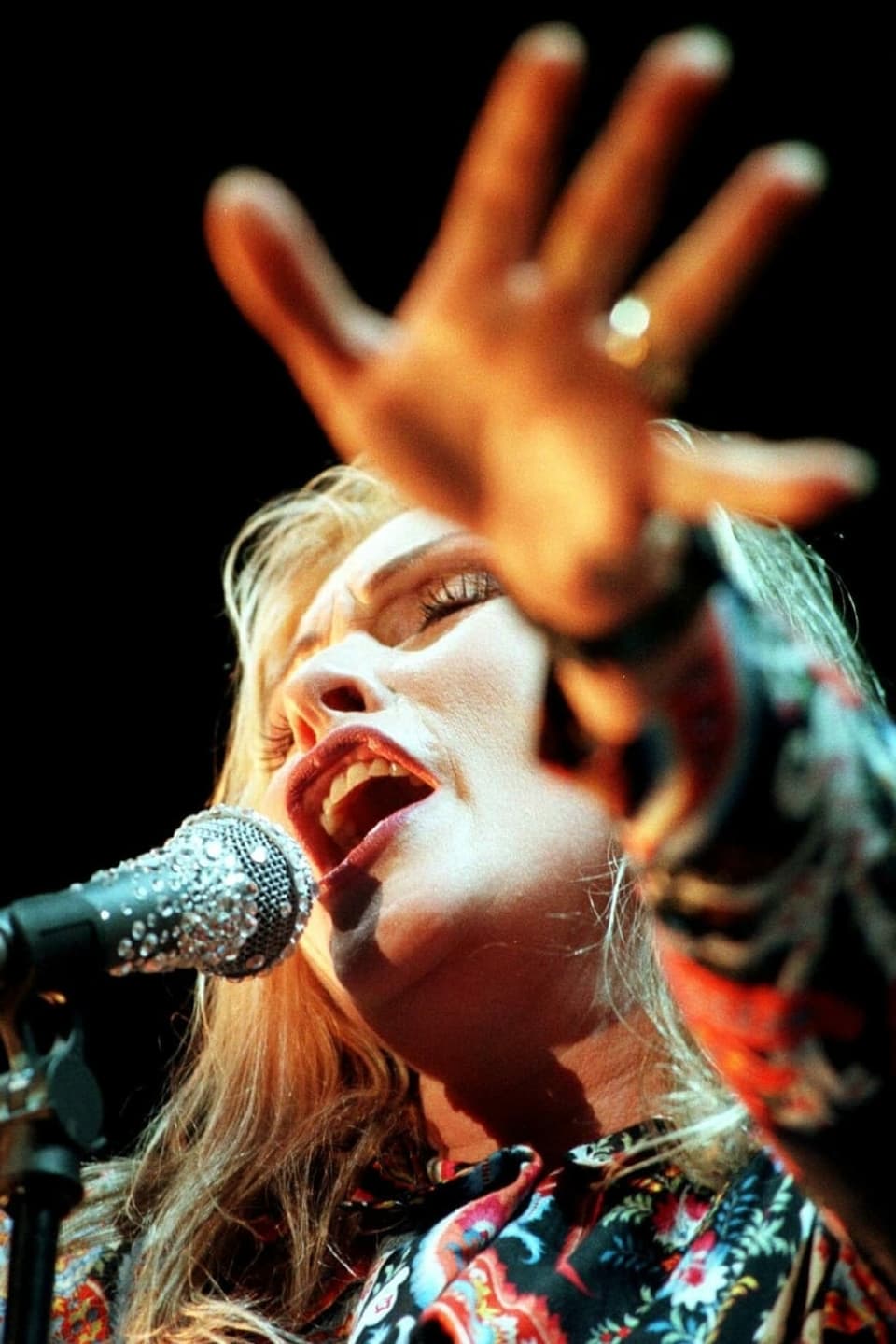 Porträtbild von Debbie Harry, sie singt in ein Mikrophon 