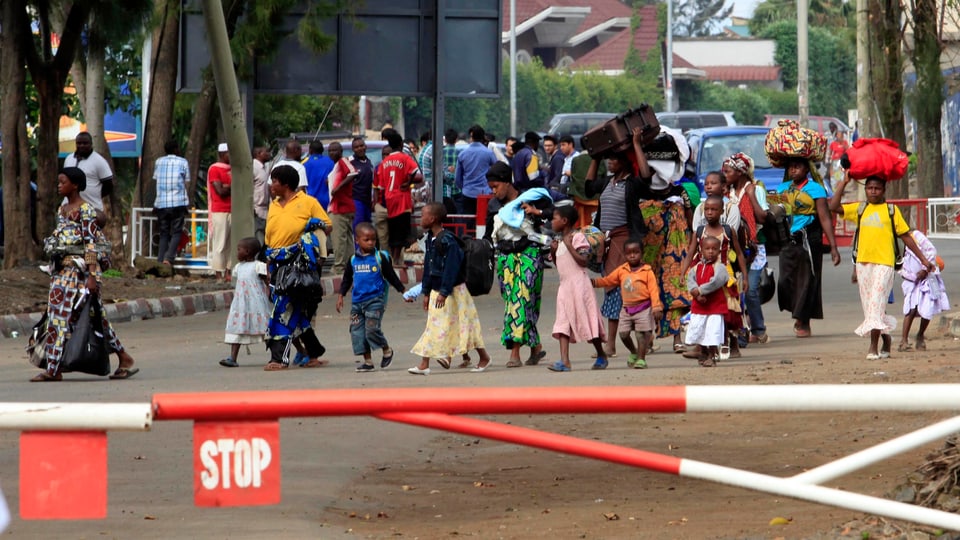 Kongolesische Flüchtlinge laufen auf einen Grenzposten zwischen Kongo und Ruanda zu. 