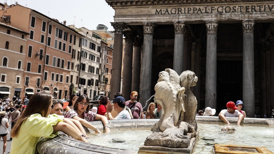 Menschen kühlen sich in einem Brunnen in Rom ab 