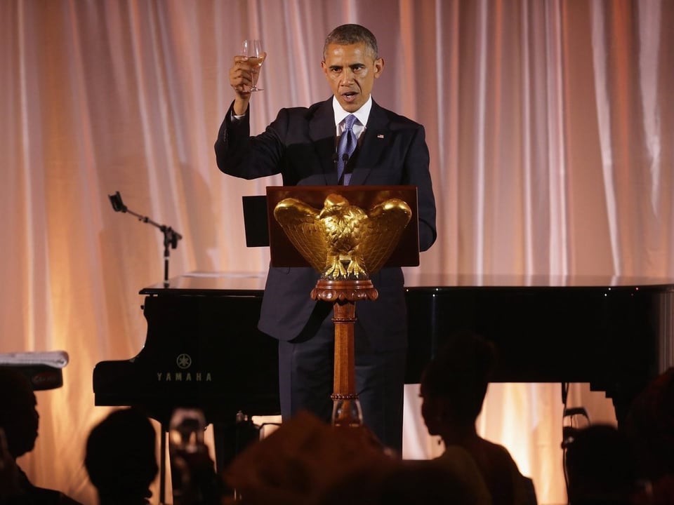 Obama am Rednerpult, er hebt ein Glas zum Toast.