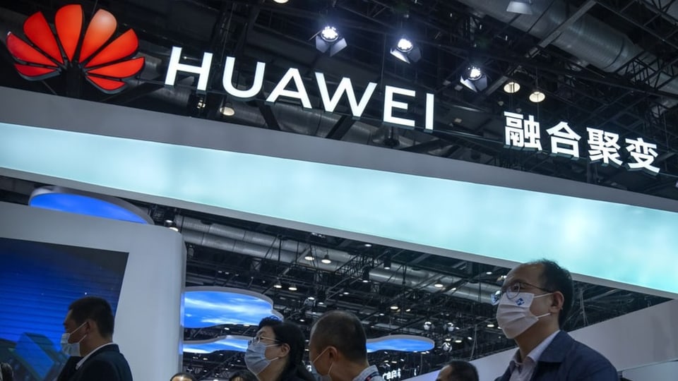 Auf dem Bild sieht man einige Asiaten vor einem Huawei-Shop.