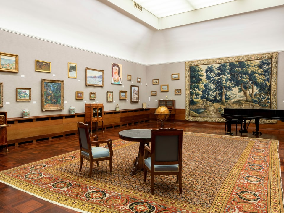 Blick in den Raum eines Museums mit Bildern an den Wänden