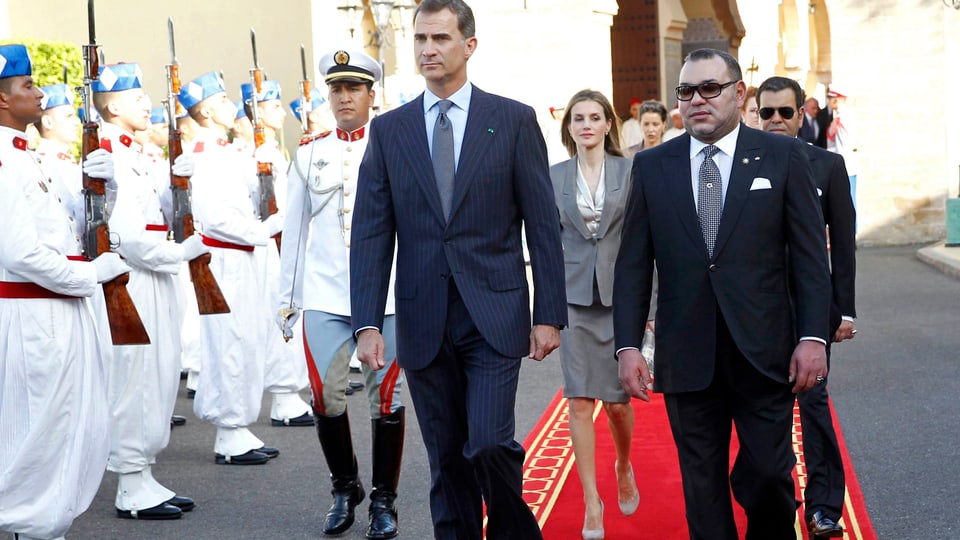 Felipe und Mohammed schreiten auf einem roten Teppich eine marokkanische Garde ab, hinter ihnen Letizia.