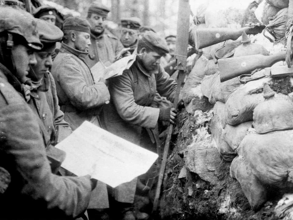 Soldaten im Schützengraben studieren einen Plan.